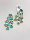 Turquoise earrings with gold accents on a light gray background
