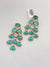 Turquoise earrings with gold accents on a light gray background